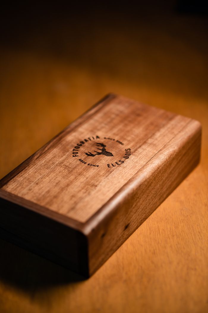 A beautifully crafted wooden box featuring an engraved deer design, set on a warm-toned surface.