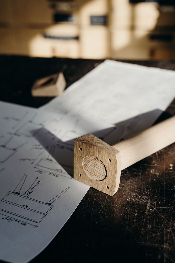 Detailed woodworking plans and tools in a sunlit workshop setting.